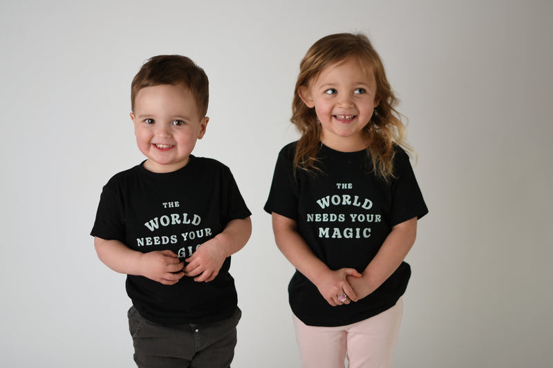 THE NEEDS YOUR WORLD Storied BLACK TEE IN – & Folk MAGIC KIDS